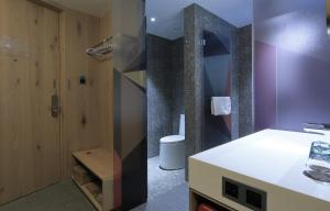W pokoju znajduje się łazienka z umywalką i toaletą. w obiekcie EBO Hotel (Hangzhou West Lake) w mieście Hangzhou