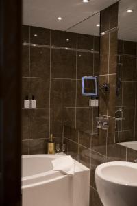 La salle de bains est pourvue d'une baignoire et d'un lavabo. dans l'établissement Hotel Epoque & Apartments, à Pietarsaari