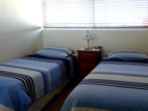a bedroom with two beds and a lamp on a table at Ebbtide 26 in Forster