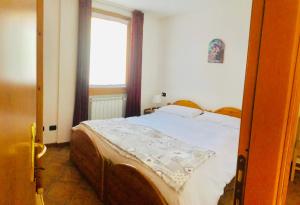 a bedroom with a bed and a window at Residence Cavallino in Ponte di Legno