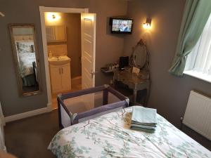 Schlafzimmer mit einem Bett, einem Waschbecken und einem Spiegel in der Unterkunft Chatterley House in Nottingham