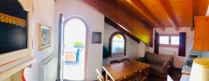 a dining room with a table and a room with an archway at Residence Cavallino in Ponte di Legno