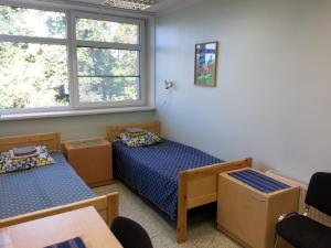 een kamer met 2 bedden, een tafel en ramen bij Guesthouse Rehab in Tartu