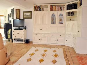 a living room with white cabinets and a tv at Ferienhaus Zirbe in Rickenbach