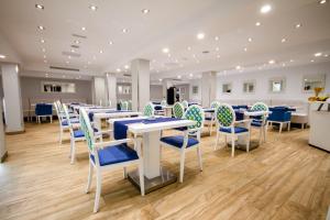 a dining room with tables and blue and white chairs at IG Nachosol Atlantic & Yaizasol by Servatur - Adults Only in Puerto Rico de Gran Canaria