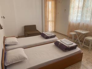 two beds in a room with a chair and a table at Къща Нанси in Sunny Beach