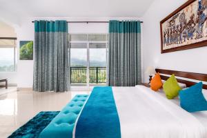 a bedroom with a large bed and a large window at Elegant Hotel in Kandy