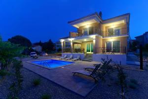 una villa con piscina di notte di Villa Nerium a Malinska