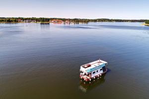 ギジツコにあるHouseboat Poland - pływający domek na Mazurachの大きな湖の中の船