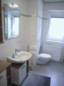 biała łazienka z umywalką i toaletą w obiekcie Haus am Sonnenberg w mieście Liesing
