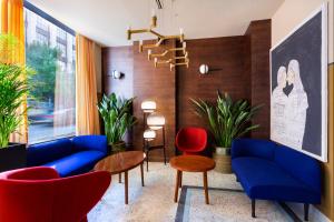a living room with blue and red furniture and plants at Zemeli Boutique Hotel by DNT Group in Tbilisi City