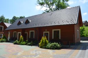 una casa marrón con techo de tejas en Apartmány Divoký Anděl, en Dolní Moravice