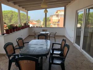 un patio con mesa, sillas y ventanas en Double Room with Terrace, en Golem