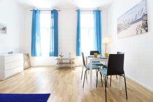 une salle à manger avec des rideaux bleus, une table et des chaises dans l'établissement MARINE: Newly renovated 2nd district apartment, à Vienne