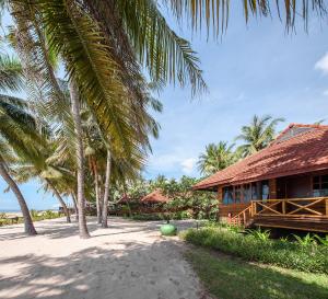 a house on the beach with palm trees at Regent - Chalet, Hua Hin in Cha Am