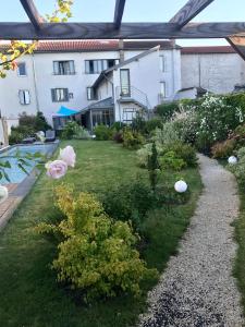 un jardin en face d'un bâtiment dans l'établissement De la Chambre au Jardin, à Belleville-en-Beaujolais