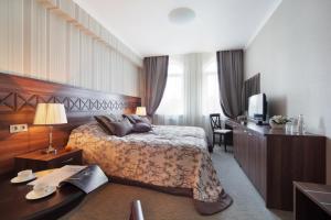 a hotel room with a bed and a television at Palais Royal in Yekaterinburg