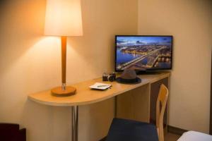 a desk with a computer and a lamp on it at Hotel Internacional Porto in Porto