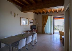 een eetkamer met een tafel en stoelen en een raam bij Apartments Golf Bogliaco in Toscolano Maderno