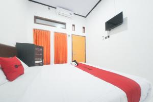 Tempat tidur dalam kamar di RedDoorz Syariah near Mall Roxy Banyuwangi 2