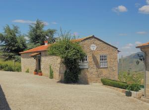une petite maison en pierre sur une route en gravier dans l'établissement Quinta da Portela - Casa Visconde Arneiros, à Lamego