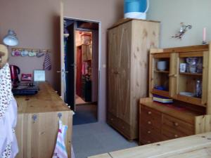 a kitchen with wooden cabinets and a door to a room at Privatzimmer für eine Person mit Kochgelegenheit in Schwerin