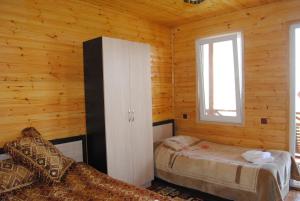 sypialnia z 2 łóżkami w drewnianym domku w obiekcie Tsanava's cottage in Sighnaghi w mieście Sighnaghi