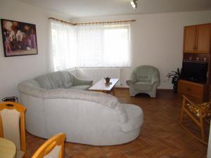 a living room with a white couch and two chairs at Holiday Home U Čápů in Lomnice nad Lužnicí