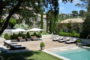 une terrasse avec des canapés et une piscine dans une cour dans l'établissement Villa Hautvallon, à Gordes