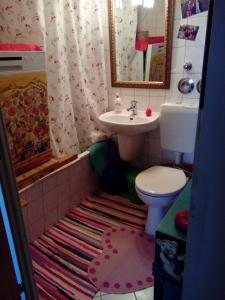 a bathroom with a sink and a toilet and a mirror at Privatzimmer für eine Person mit Kochgelegenheit in Schwerin