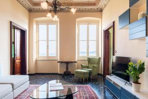 a living room with a couch and a tv at Carlotta Flexyrent Apartment in Rapallo