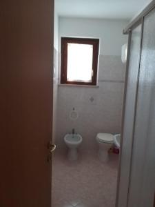 ein Bad mit einem WC, einem Waschbecken und einem Fenster in der Unterkunft STELLA 1 in Roseto degli Abruzzi