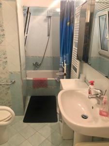 a bathroom with a sink and a toilet and a shower at Via Cimarosa in Follonica