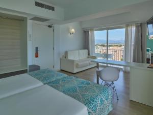 カン・パスティーリャにあるBQ アポロホテルのベッド、テーブル、ソファが備わるホテルルームです。