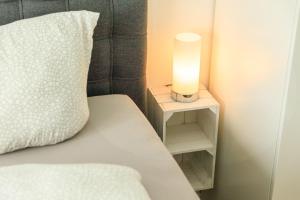 a bed with a pillow and a candle on a night stand at Modern Apartment in city center in Würzburg