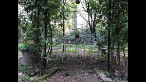 une porte dans un jardin avec un banc et des arbres dans l'établissement Casa luminosa con giardino in centro storico, à Reggio d'Émilie