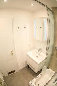 a white bathroom with a sink and a mirror at Modern Apartment in city center in Würzburg