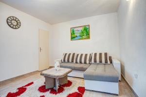 ein Wohnzimmer mit einem Sofa und einem Tisch in der Unterkunft Stojkovic Family Apartments in Tivat