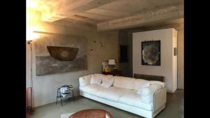 ein Wohnzimmer mit einem weißen Sofa und einem Gemälde in der Unterkunft Casa luminosa con giardino in centro storico in Reggio nell'Emilia
