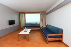 a living room with a blue couch and a table at Cimer SafraMarine Beach Resort in Safra