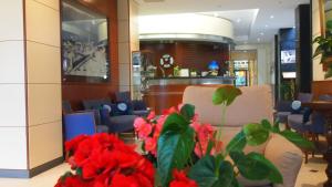 een lobby met een wachtkamer met rode bloemen bij Piccolo Hotel in Moneglia