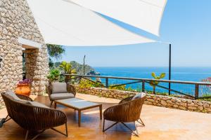 
a patio area with chairs and a table with an umbrella at Casa Trevelyan Isola Bella in Taormina
