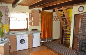 a kitchen with a washing machine and a ladder at Domek w Sajenku in Augustów