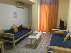 un soggiorno con 2 divani e una TV di Jason Hotel Apartments a Rethymno