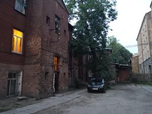 een auto geparkeerd in een steeg naast een bakstenen gebouw bij Artilerija's apartment in Rīga
