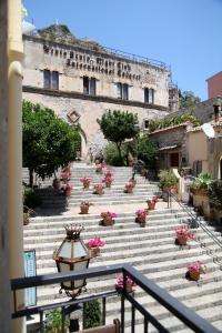 eine Gruppe Treppen mit Blumen in einem Gebäude in der Unterkunft Bed & Breakfast Duomo Di Taormina in Taormina