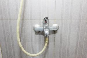 a hose hooked up to a wall in a shower at Embe Joglo Homestay in Yogyakarta