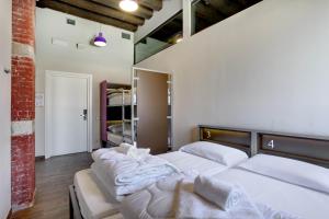- une chambre avec 2 lits et des draps blancs dans l'établissement Generator Venice, à Venise