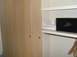 a microwave sitting on a shelf in a room at Hôtel Le Parc in Marly-le-Roi