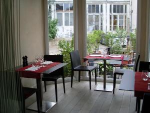 a restaurant with two tables and chairs and a window at Hôtel Le Parc in Marly-le-Roi